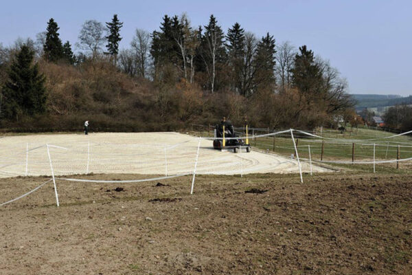 Maschine bereitet die sandige Tretschicht eines Reitplatzes auf