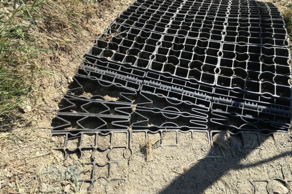 Nahansicht von ECORASTER Bodengitter, die mit Universalwinkel und Kurvenelement für Wege im Gelände befestigt wurden