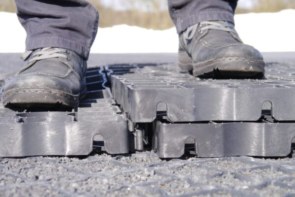 Arbeiter steht auf zwei ECORASTER um zu zeigen, wie leicht diese voneinander zu lösen sind.