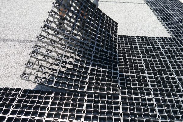 Eine Lage ECORASTER wird an auf dem Boden liegende ECORASTER Fläche angelegt.
