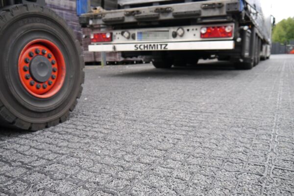 Nahaufnahme einer Schotter befüllten ECORASTER Fläche mit LKW