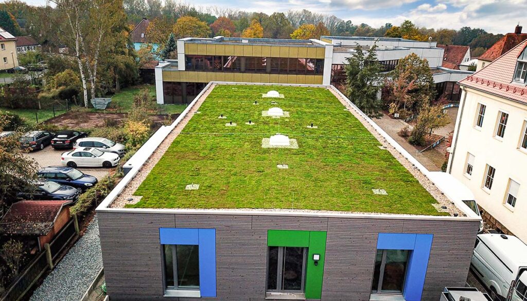 Dachbegrünung ECOgreen PACK auf einer Kita in Mainleus umgeben von Häusern und parkenden Autos